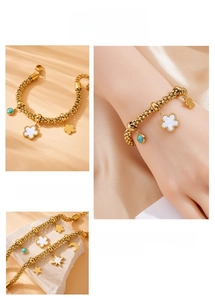 Detail of gold chain bracelet with enamel flowers, moon, star and turquoise charms