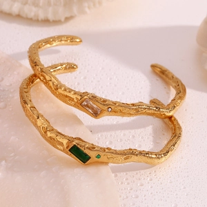 Detail of 18K gold-plated open cuff with lava texture and rectangular zircon stones