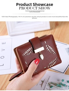Detail of brown leather wallet with gold leaf embroidery and metal leaf charm closure