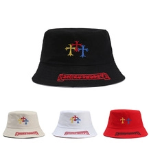 Detail of tie-dye bucket hat featuring cross embroidery and gothic letter stitching