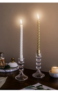 Dettaglio dei portacandele in vetro a coste con eleganti candele a spirale in un ambiente caldo