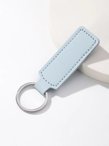 Close-up of light blue leather keychain with silver metal ring and fine stitching detail