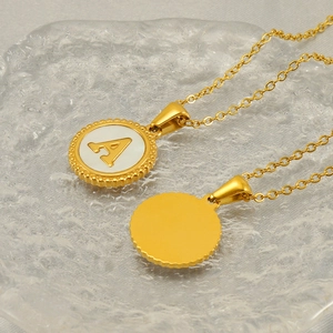 Gold stainless steel letter A necklace with white shell inlay pendant on glass plate
