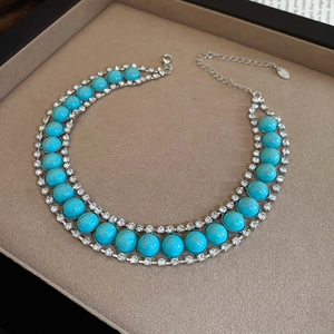 Détail d'un collier bohème argenté avec turquoise et strass dans son coffret cadeau