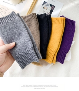 Detailed close-up of colorful knitted fingerless gloves in gray, beige, black, and yellow