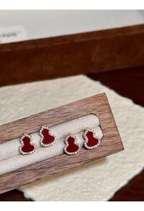 Detailed view of gourd-shaped earrings with red enamel and pavé zircon in rose gold