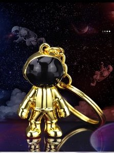 Macro view of polished gold astronaut keychain made of high-quality zinc alloy