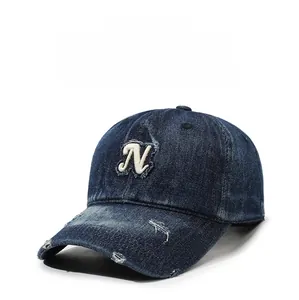 Close-up of distressed denim baseball cap showing Letter N embroidery and vintage holes
