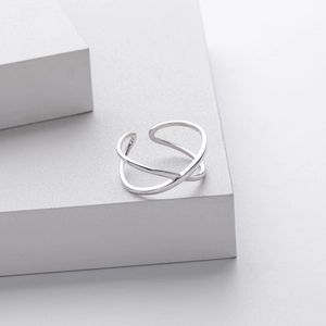 Minimalist s925 silver overlapping crossed lines ring on a white geometric block