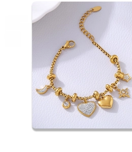 Detail of a gold adjustable bracelet with star, moon, and cubic zirconia heart charms