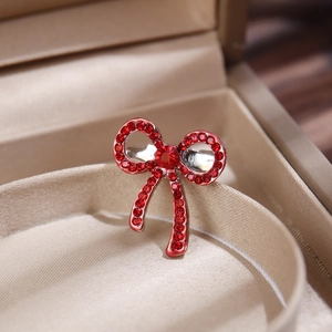 Detailed macro view of a red rhinestone butterfly brooch in a beige jewelry gift box