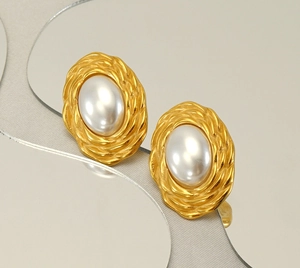 Macro detail of vintage gold braided twist earrings with a central white pearl inlay