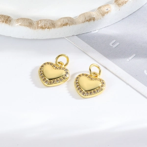 Detailed view of small gold heart pendants with crystal border for DIY jewelry making