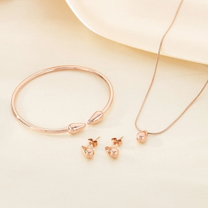 Détail de l'ensemble de bijoux goutte d'eau en or rose avec collier, bracelet et boucles
