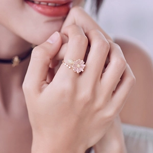 Adjustable rose gold daisy ring featuring pink enamel petals and sparkling small crystals