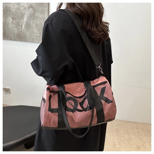 Detail of pink mesh gym bag with black handles and LOOK lettering shown on a model