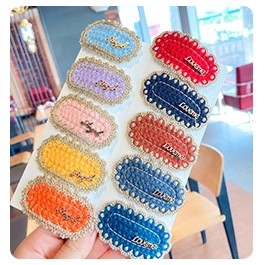 Detailed set of 10 colorful knitted and leather hair clips with golden Angel and Love lettering
