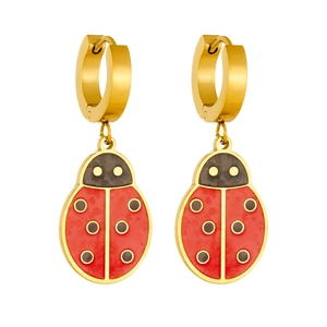 Macro detail of ladybug earrings with red and black enamel on gold-plated hoops