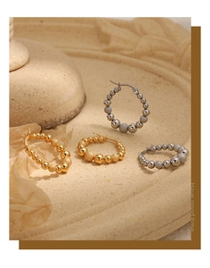 Detail of beaded stainless steel hoop earrings with polished and frosted textures