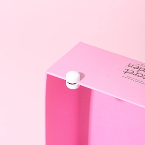 Close-up of the white magnetic clasp on a premium pink gift box with elegant typography