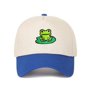 Detail of embroidered frog and lotus leaf on a two-tone cotton trucker baseball cap