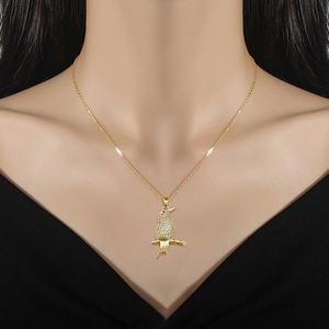 Golden parrot necklace with white zircons and red eye gemstone on female model