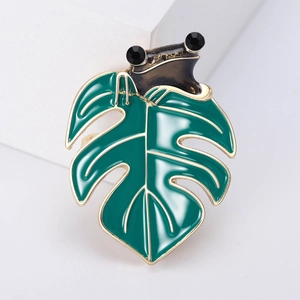 Vintage enamel frog brooch on green leaf with golden accents and crystal eyes