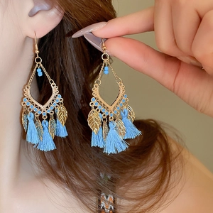 Close-up of Bohemian drop oil leaf earrings with blue tassels and golden finish details