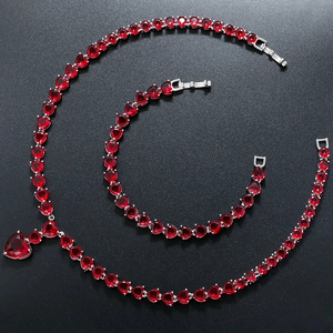 Detailed view of luxury heart jewelry set featuring red heart-shaped gems and silver chain
