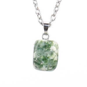 Close-up of a natural green and white stone pendant with silver chain on white background