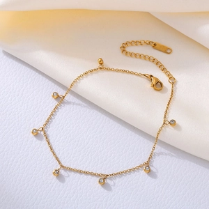 Gold stainless steel beaded anklet with clear cubic zirconia on beige silk fabric