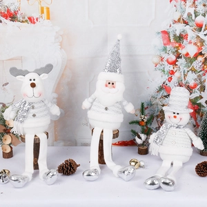Silver plush Santa, snowman, and reindeer Christmas figurines sitting by the fireplace