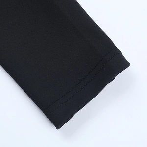Detalle del puño de un vestido negro de manga larga con doble costura reforzada