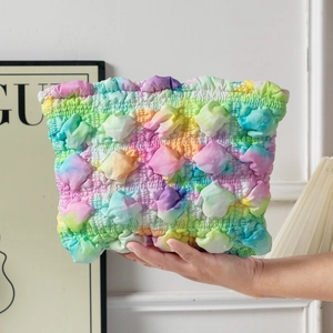 Detailed macro view of the 3D bubble fabric texture on this colorful tie-dye pleated bag