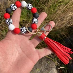 Detail of red and leopard print silicone bead keychain bracelet with red PU tassel charm