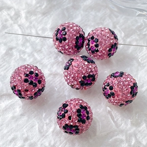 Detail van roze polymeerklei kralen met zwarte strass patronen voor DIY sieraden maken