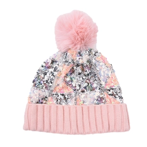 Dettaglio berretto in maglia con paillettes rosa, motivi geometrici e pompon di pelliccia