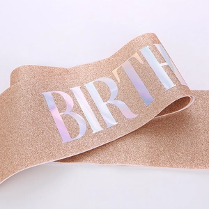 Close-up of rose gold glitter sash with laser holographic BIRTH text for parties