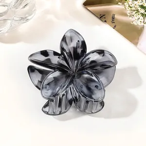 Detail of smoky gray flower hair claw with gradient marble texture and acrylic teeth