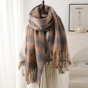 Detailed view of the thick brown and grey plaid scarf with fringes on a mannequin