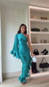 Detail of turquoise satin one-shoulder maxi dress with ruffled hem and silky texture