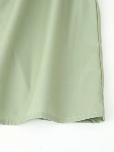 Detail shot of light green fabric texture with precision double-stitched hem and draping