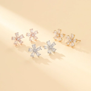 Detail of flower stud earrings in rose gold, silver, and gold with drop-shaped zirconias