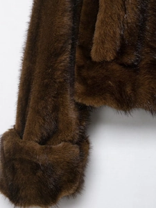 Detail van donkerbruin imitatiebont jack met zachte textuur en afwerking van de mouwen
