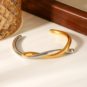 Two-tone twisted gold and silver stainless steel open bangle with a polished mirror finish