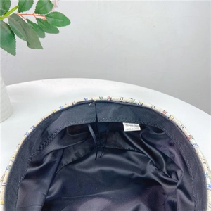 Detailed close-up of the black satin lining and woven care label inside the beret hat