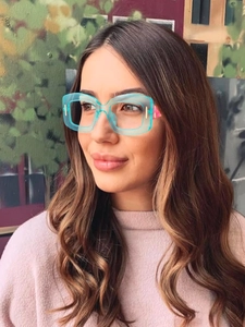 Detail of square oversized light blue transparent glasses with pink camouflage temples