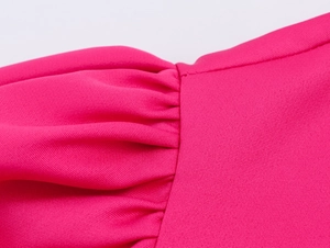 Detailansicht der hellrosa Stoffnähte und des Plissee-Designs an diesem eleganten Crop-Set