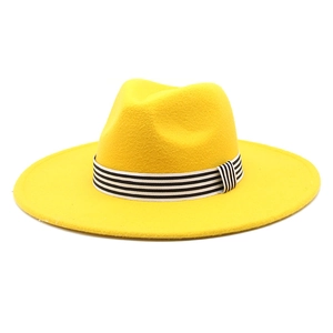 Macro shot of yellow wool felt fedora featuring classic black and white striped ribbon
