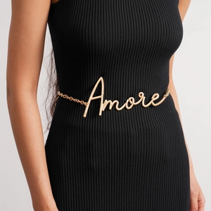 Detailansicht der goldfarbenen Amore-Taillenkette auf schwarzem geripptem Kleid